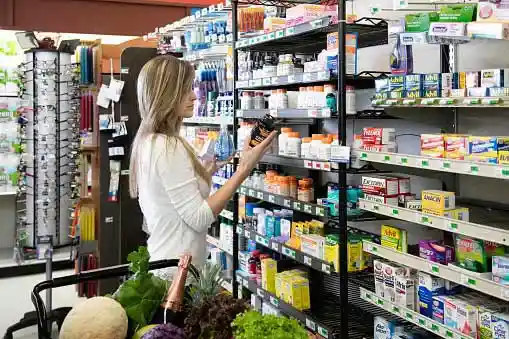 woman at drugstore reading package label